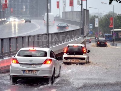 COD PORTOCALIU de ploi în Capitală: Mai multe tramvaie și troleibuze sunt blocate. Străzi inundate, copaci doborâți de vânt și mașini avariate. Circulația la metrou, blocată la Pipera