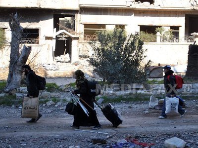 Sute de civili sirieni, epuizați, evacuați din cartiere rebele de la Homs